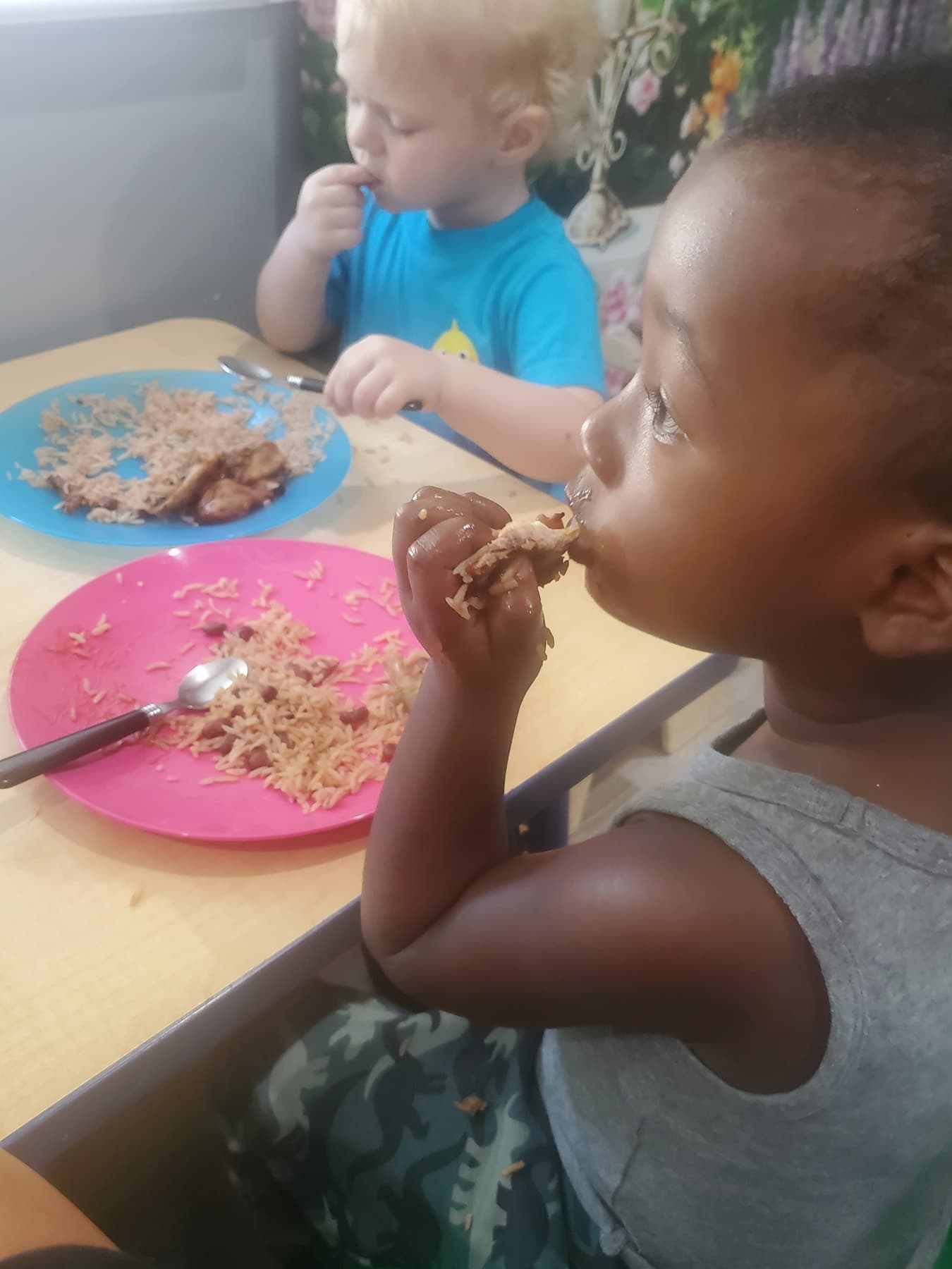 Children eating lunch at a small daycare table