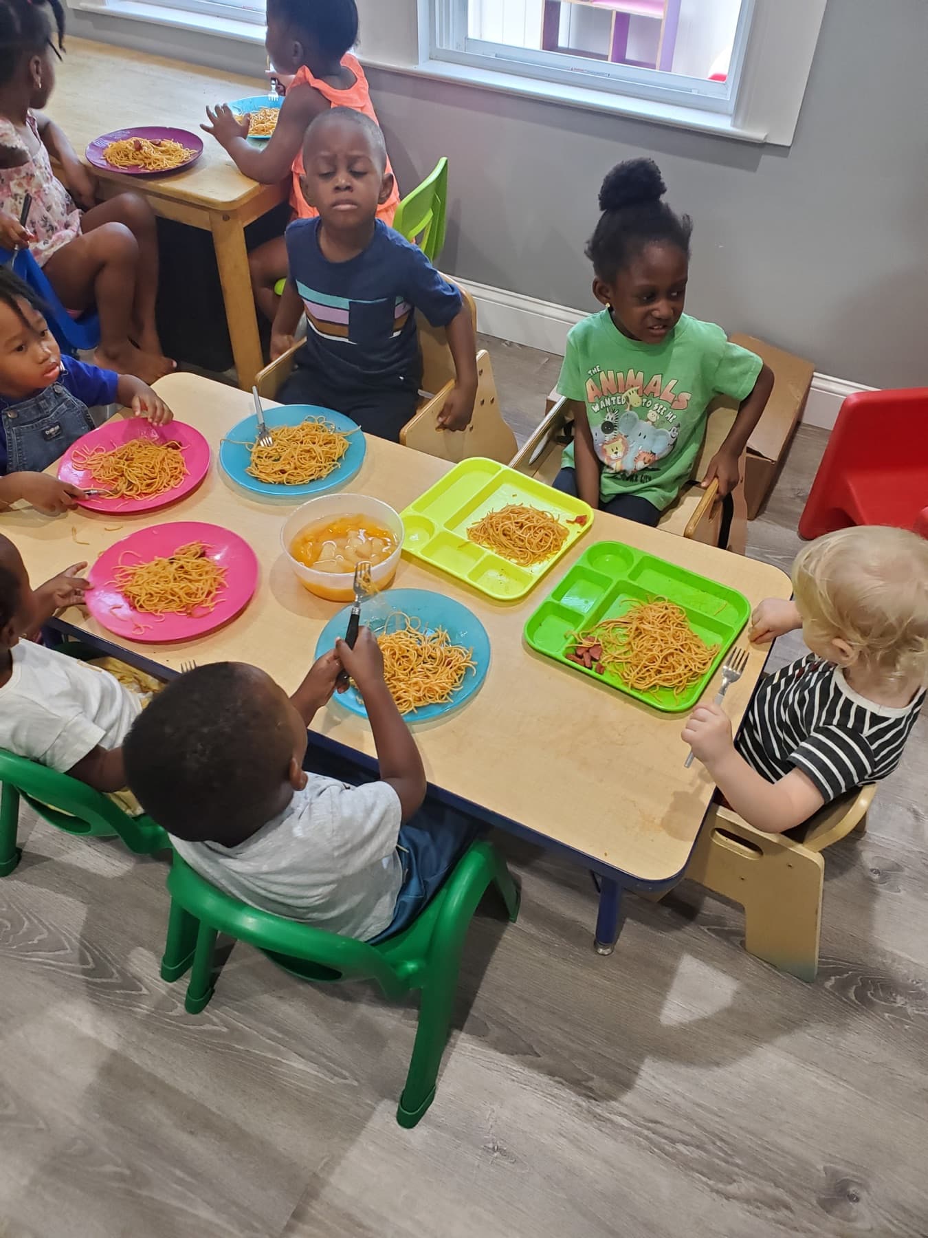 Children seated together at the daycare table for lunch