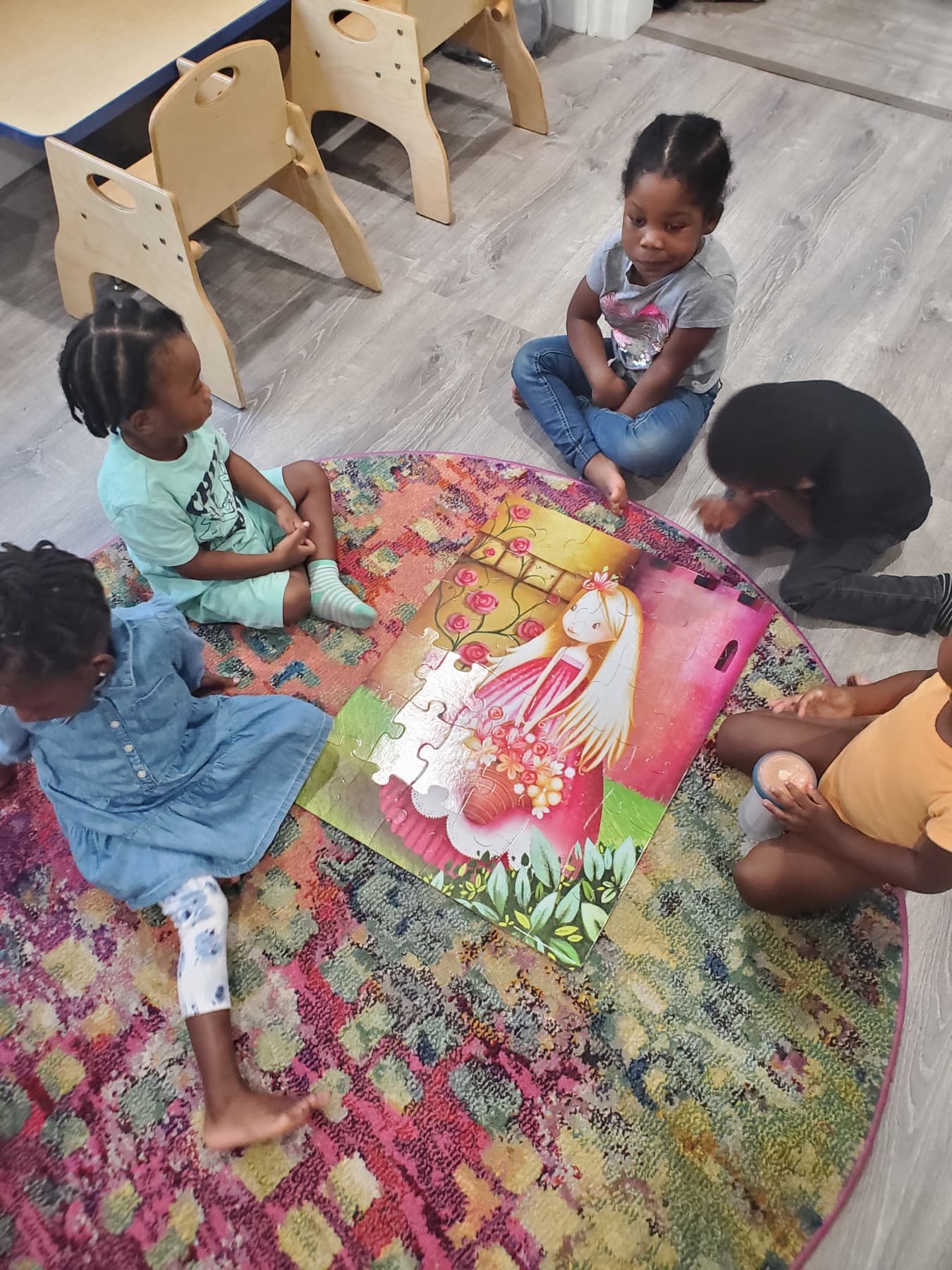 Children sitting together for puzzle time in the daycare classroom
