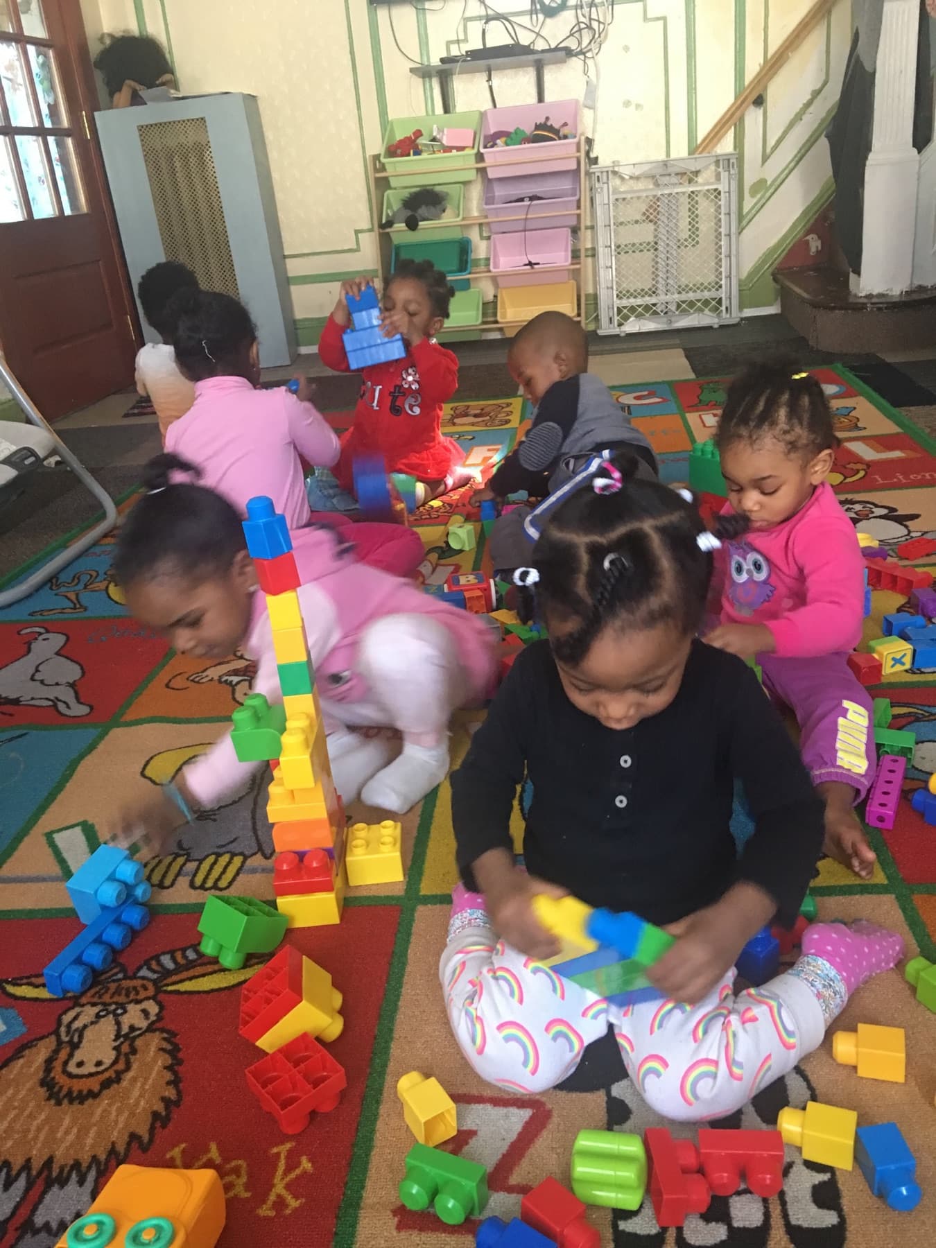 Children building with colorful blocks on a classroom rug