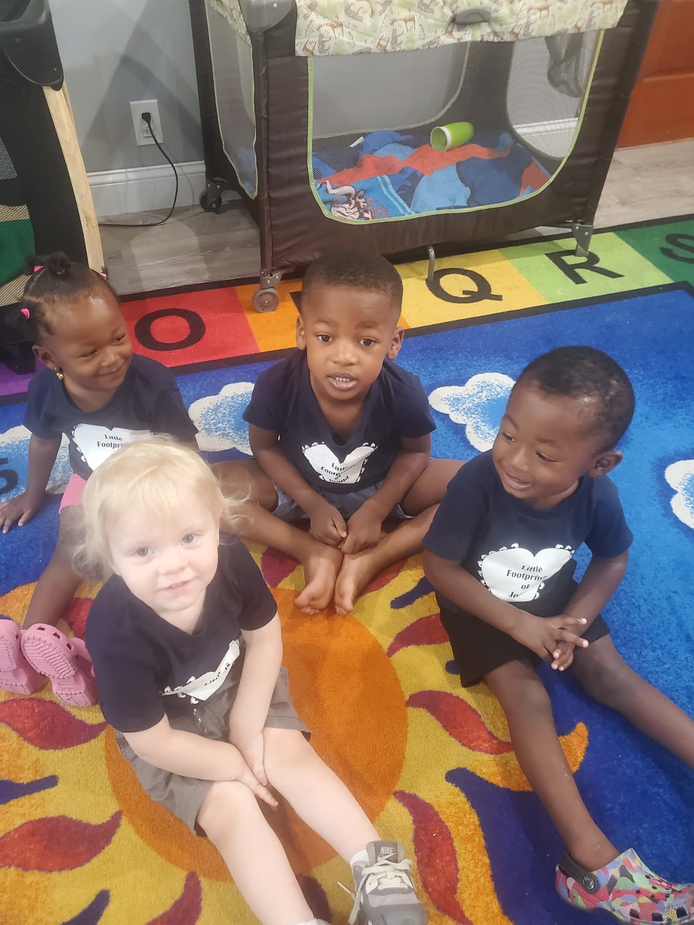 Children gathered together in Little Footprints daycare shirts