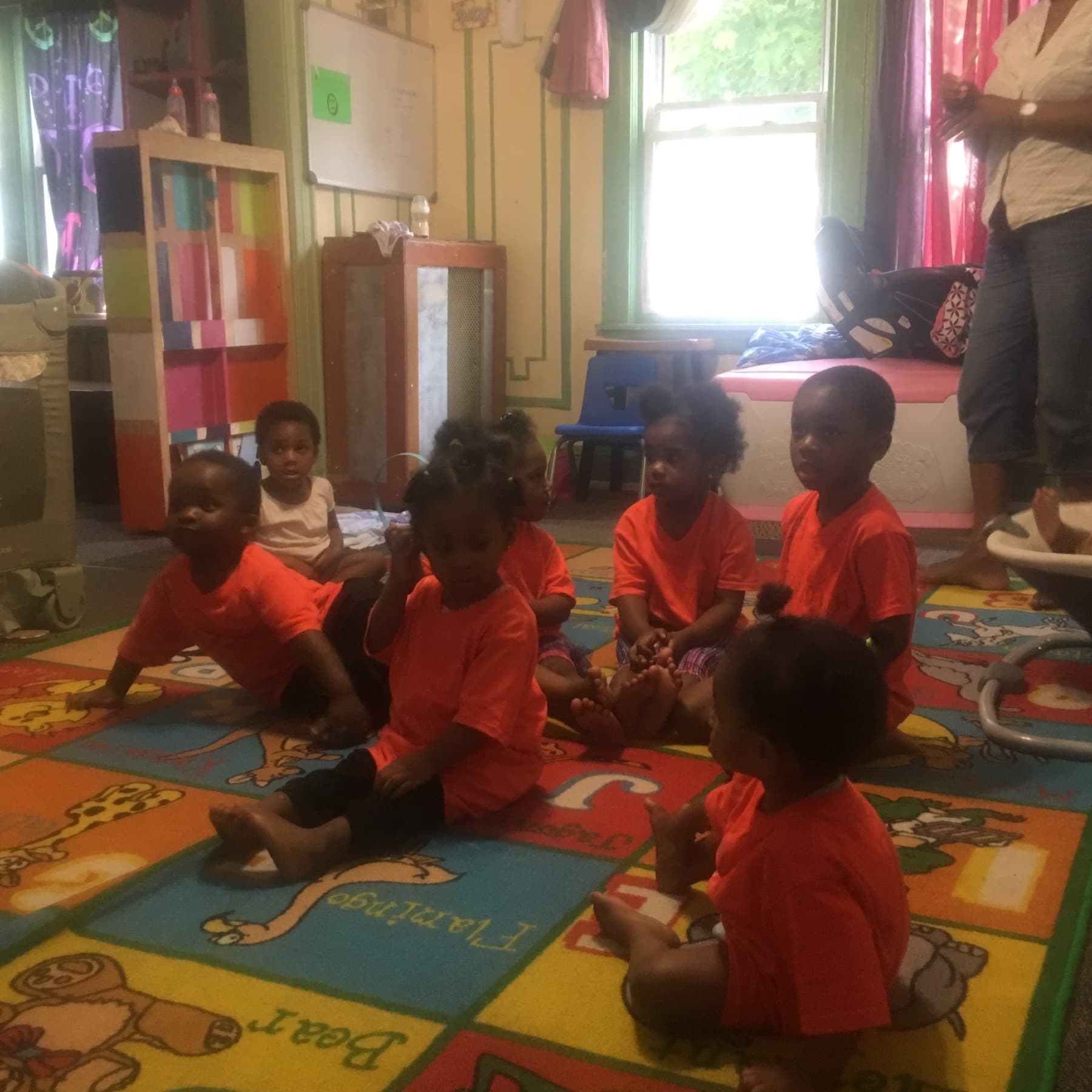 Children seated together for group time on a classroom rug