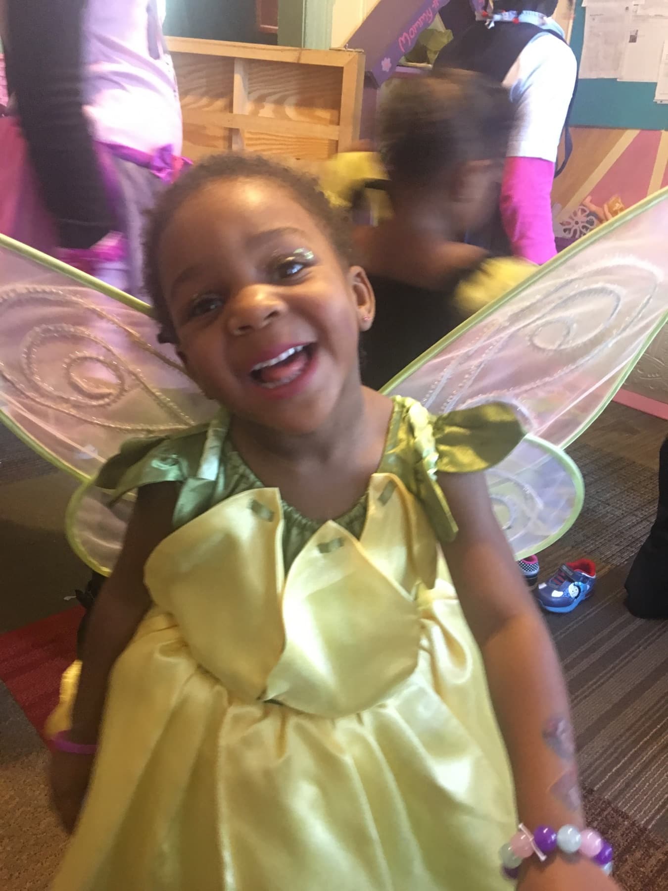 Child laughing in costume during a daycare celebration