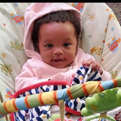 Infant seated in a soft play seat